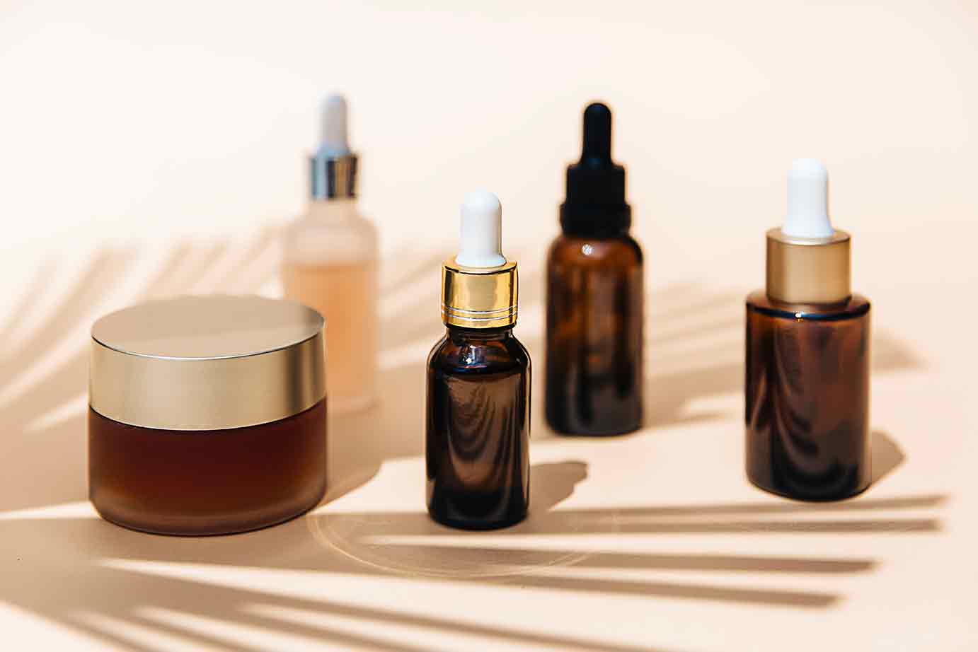 Spa cosmetics in brown glass bottles on brown background